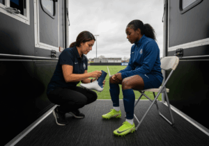 podologue consultant la semelle orthopédique d'un footballeur